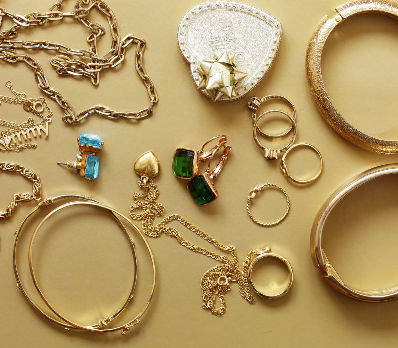 assortment of jewelry for auction on a gold color table